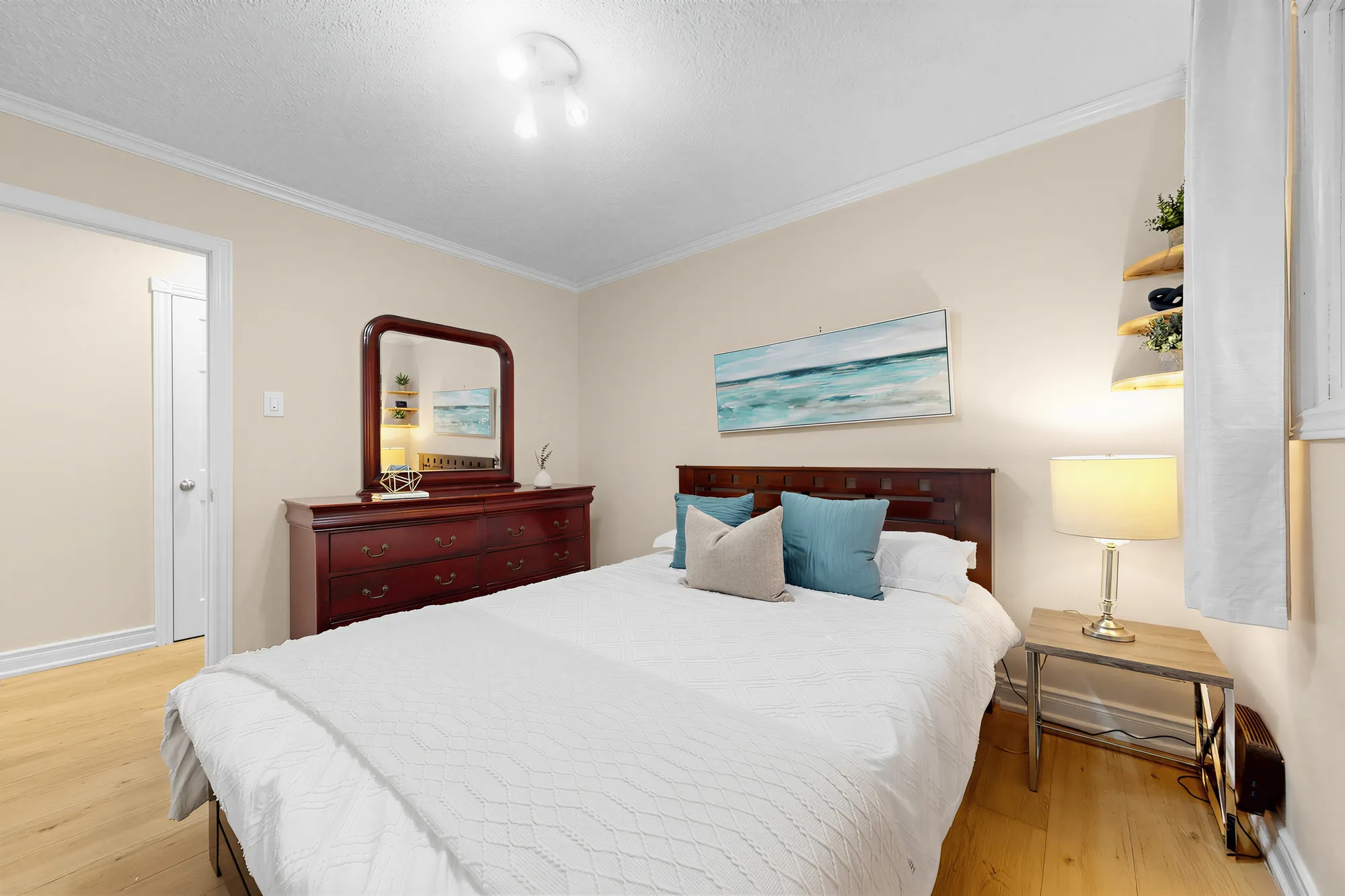 The same bedroom toward the dresser and mirror, the doorway at the left
