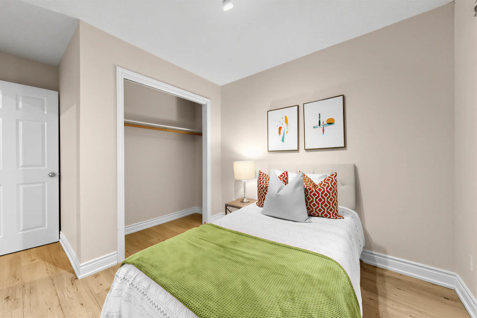 The same bedroom toward its open closet and the door
