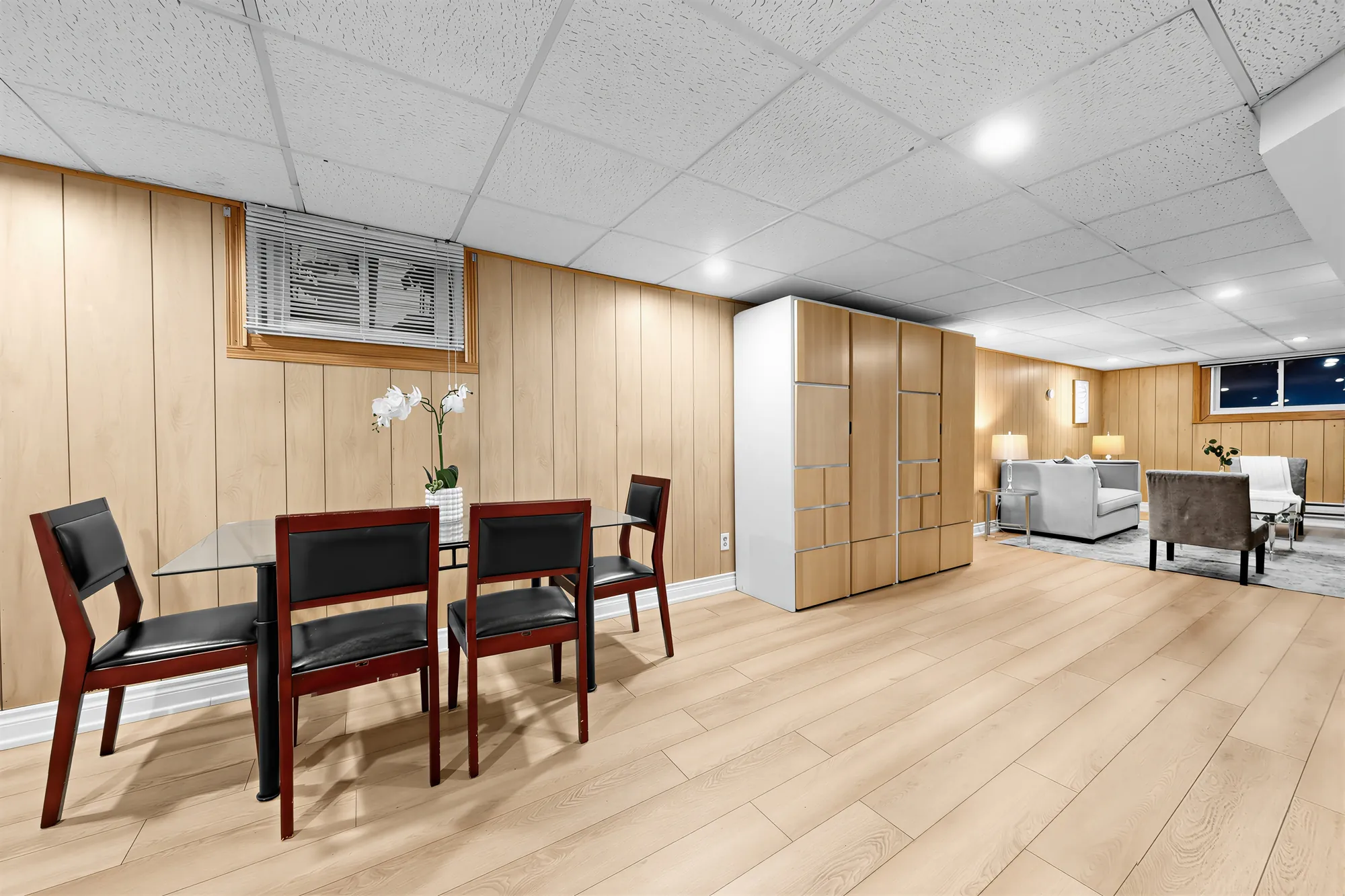 The dining table toward the family room, a window high on the panelled wall