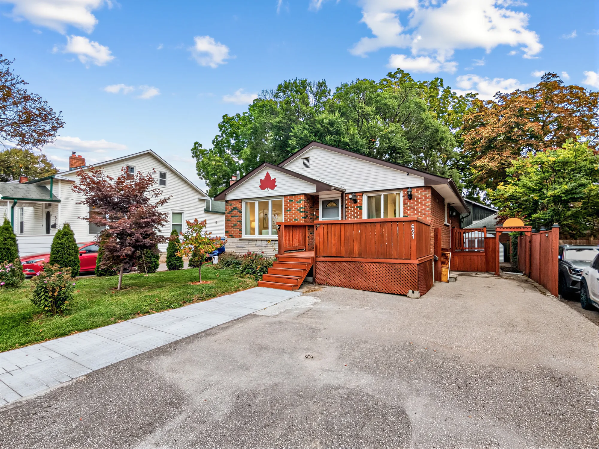 The house from the drive: the deck and its steps, the wide drive, a gate to the side path, the number 621 on the deck railing