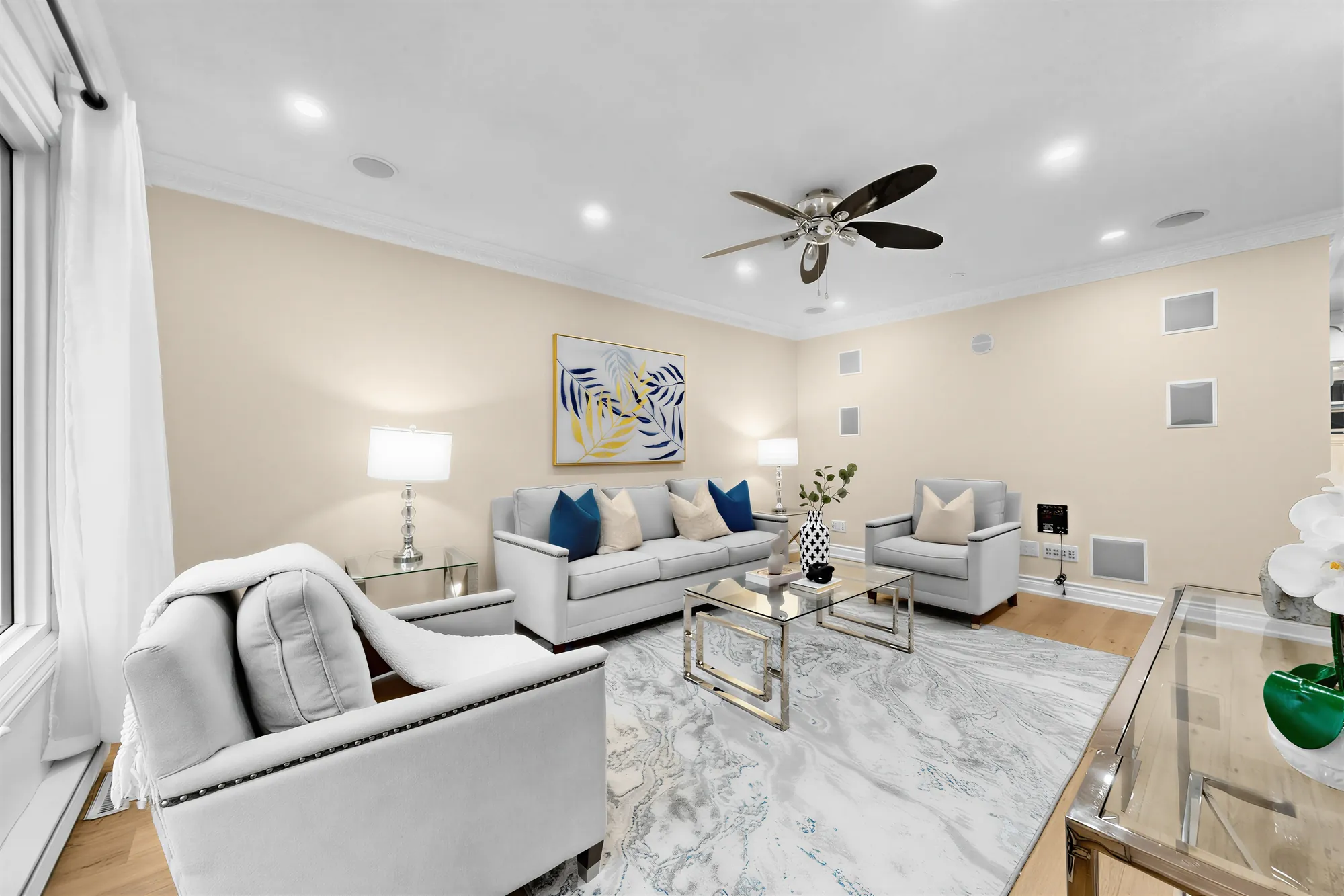 The living room toward the sofa and the side wall, the armchair in the foreground, a framed print and table lamps